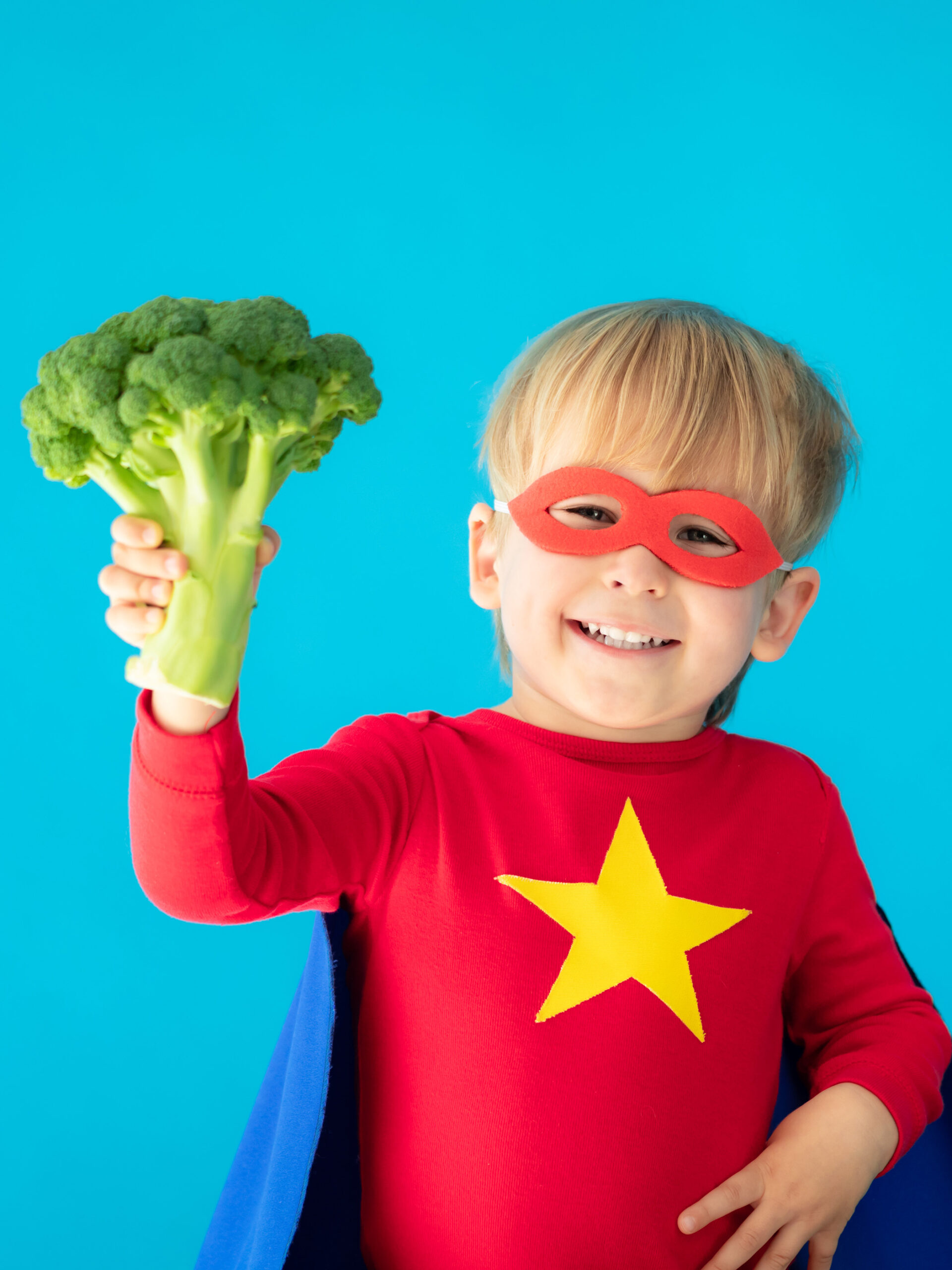 Child in cape holds broccoli - superfoods for kids from a CHOC registered dietitian