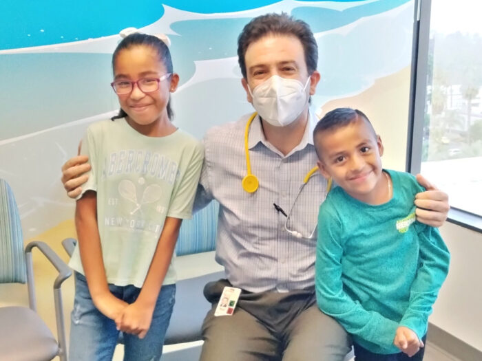 Siblings Julissa and Joseph smile with Dr. Pierangelo Renella 