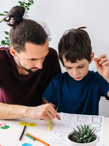 Child and man look at homework together - what parents should know about Asperger's - CHOC