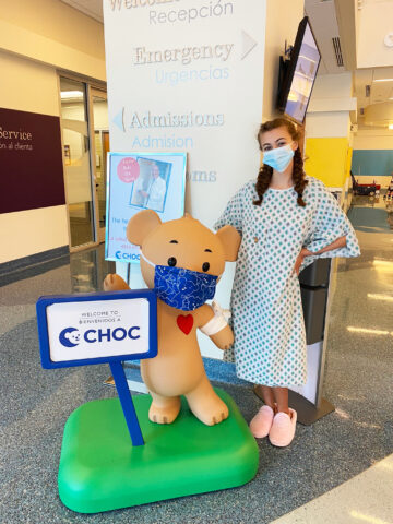 Sarah poses with CHOC at CHOC Hospital in Orange while there for scoliosis surgery