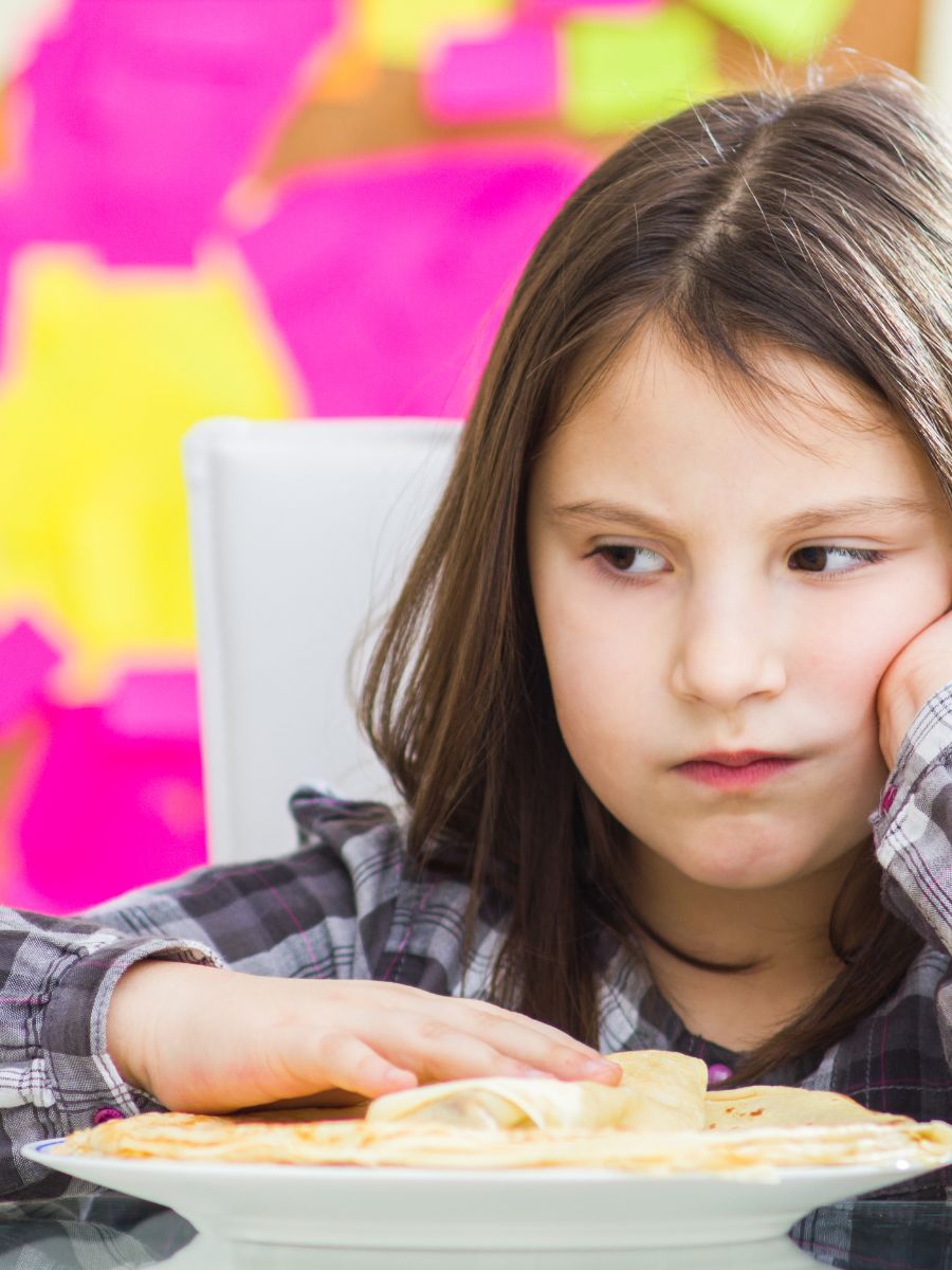 girl with brown hair disinterested in meal