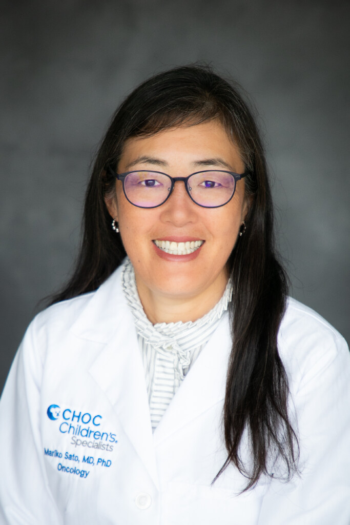 Headshot Dr. Mariko Sato, director of CHOC’s Brain and Spine Tumors Program - woman with black hair and glasses smiles while wearing white doctor's coat