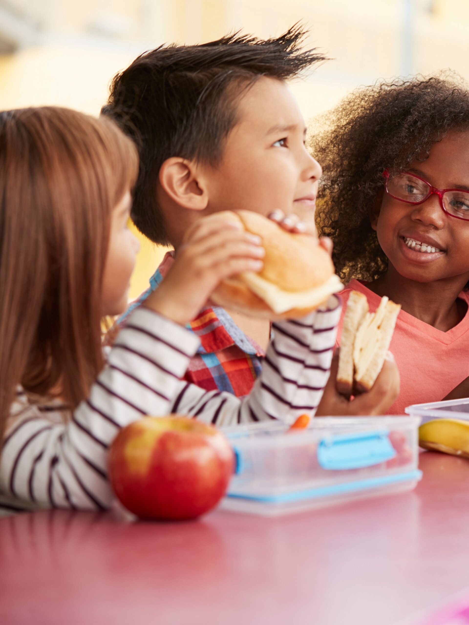 young students eating lunch at a big table