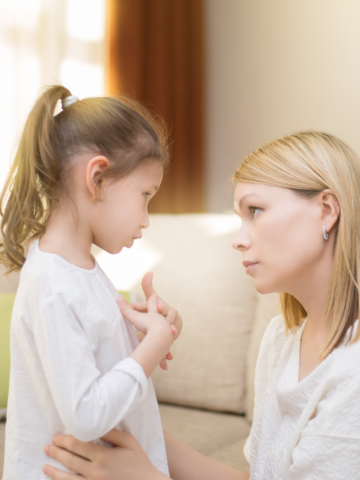 blond woman talks to little girl with pony tail