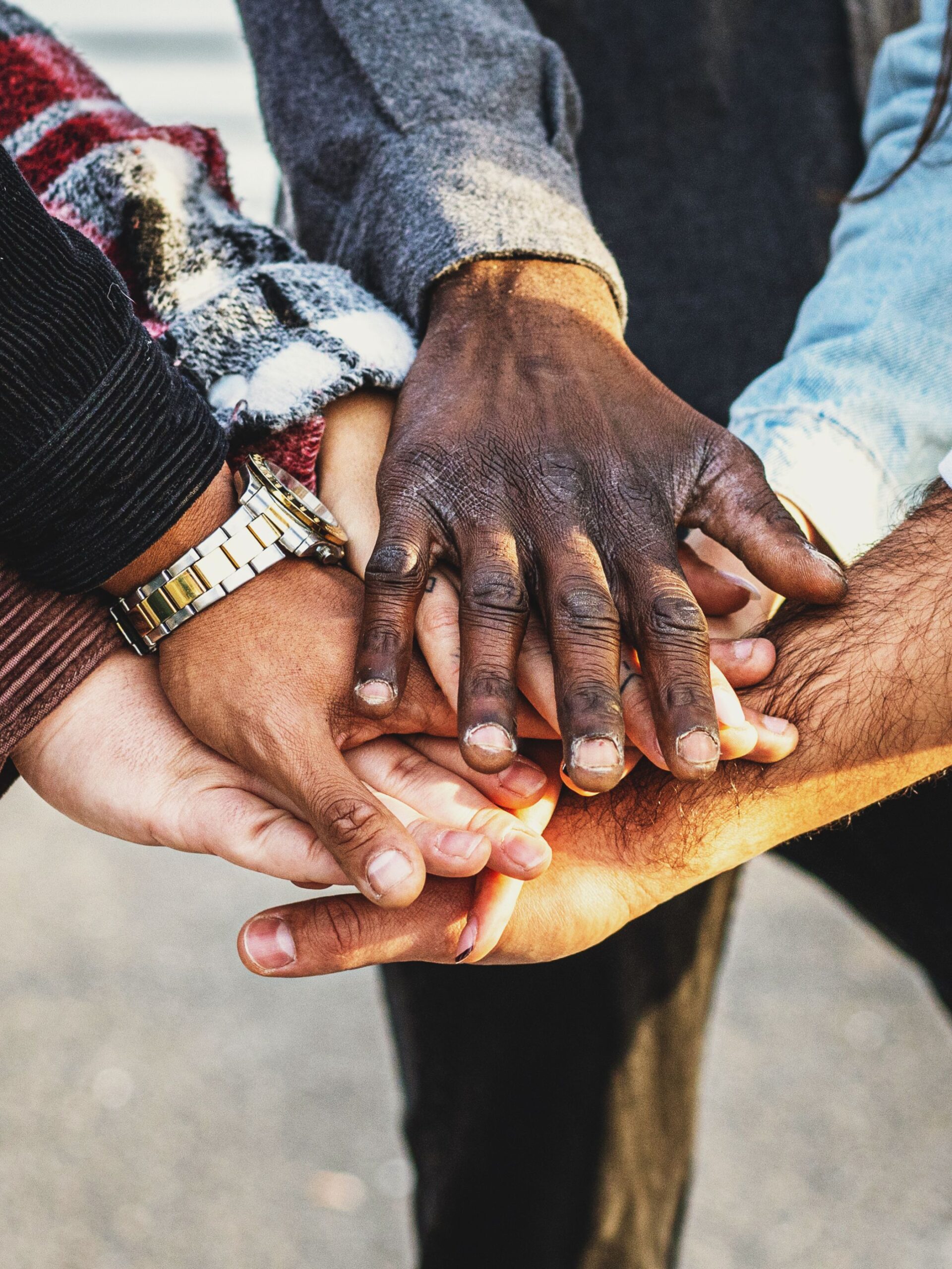 people's hands stacked on top of each other