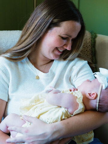 Woman in white shirt holds baby in arms