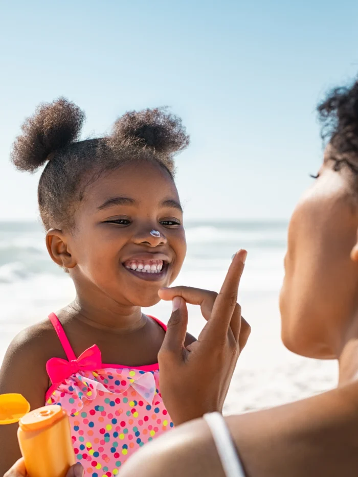 Mom putting sunscreen on child