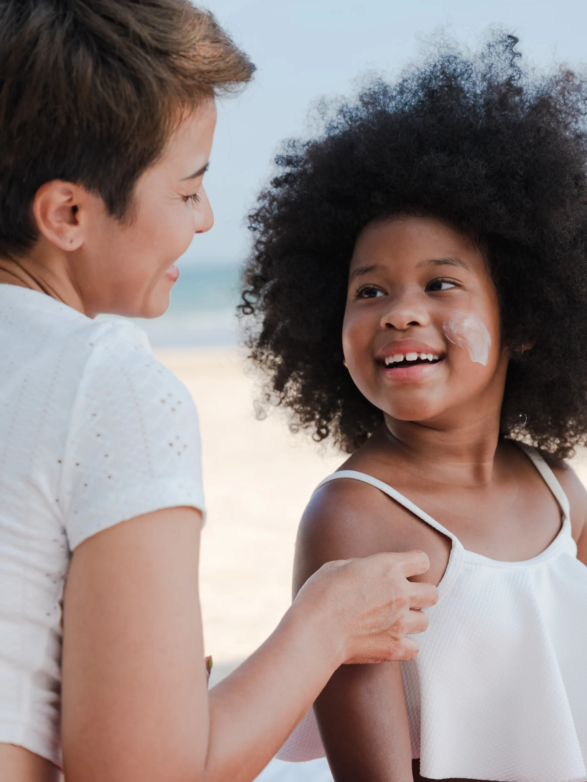 Mom putting sunscreen on child