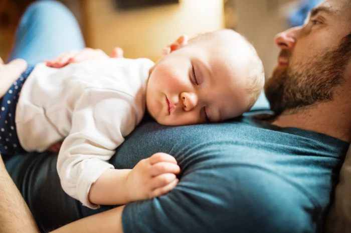 Baby lays on father's chest 