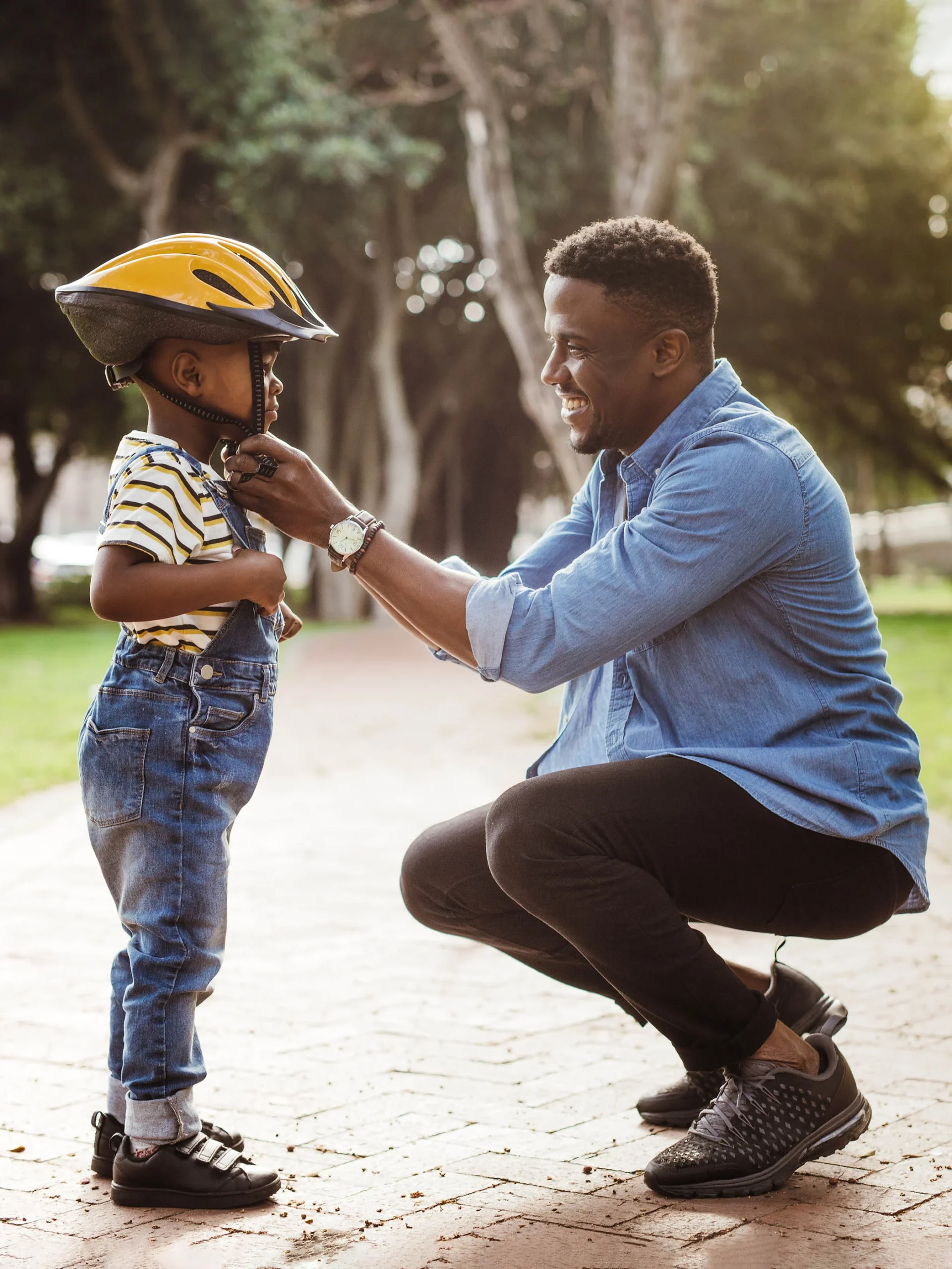 Dad buckles helmet of child