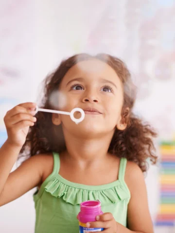 child blowing bubbles