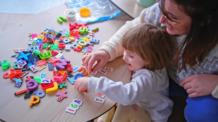 Three-year-old and parent work on puzzle together