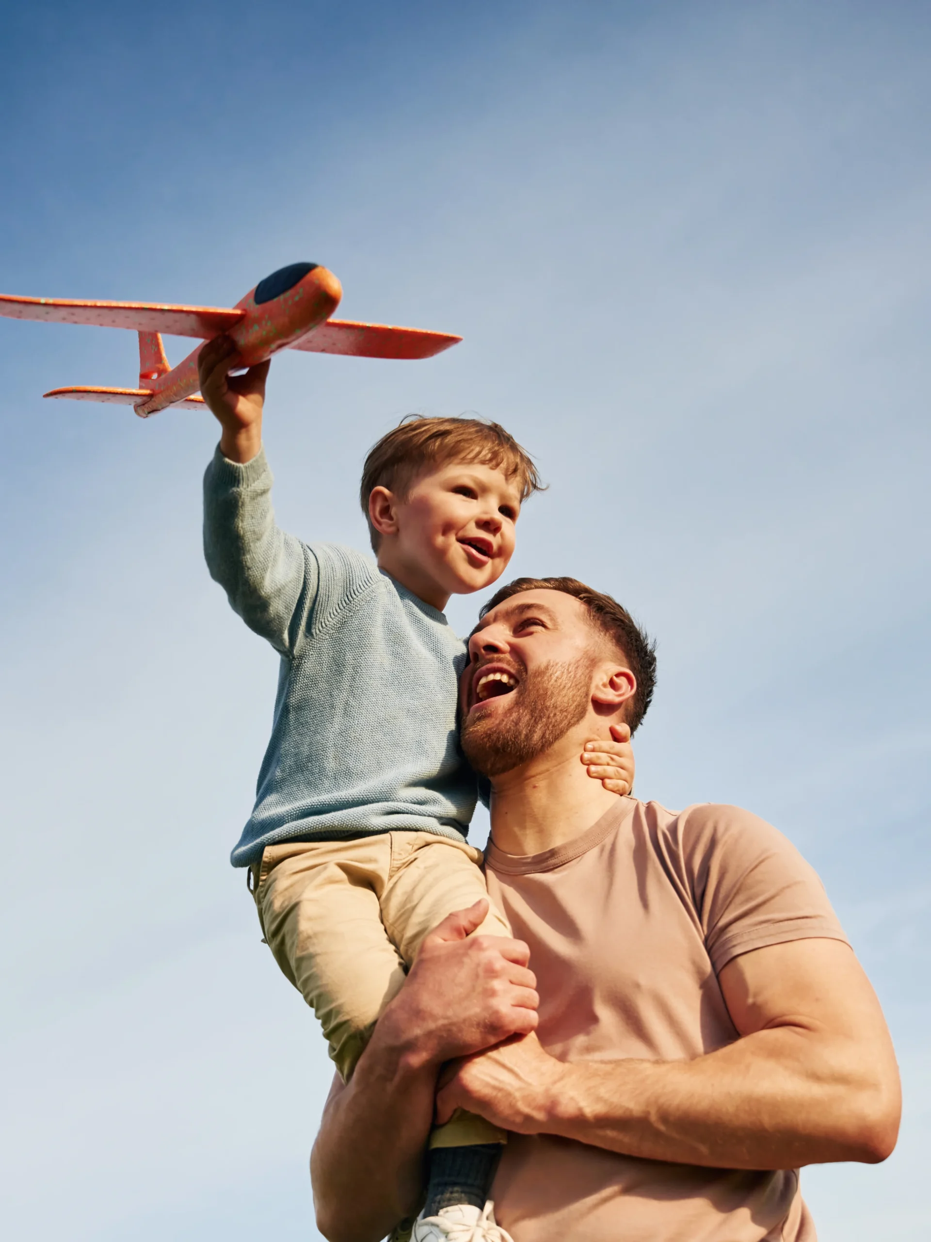 Parent and child playing with toy plane