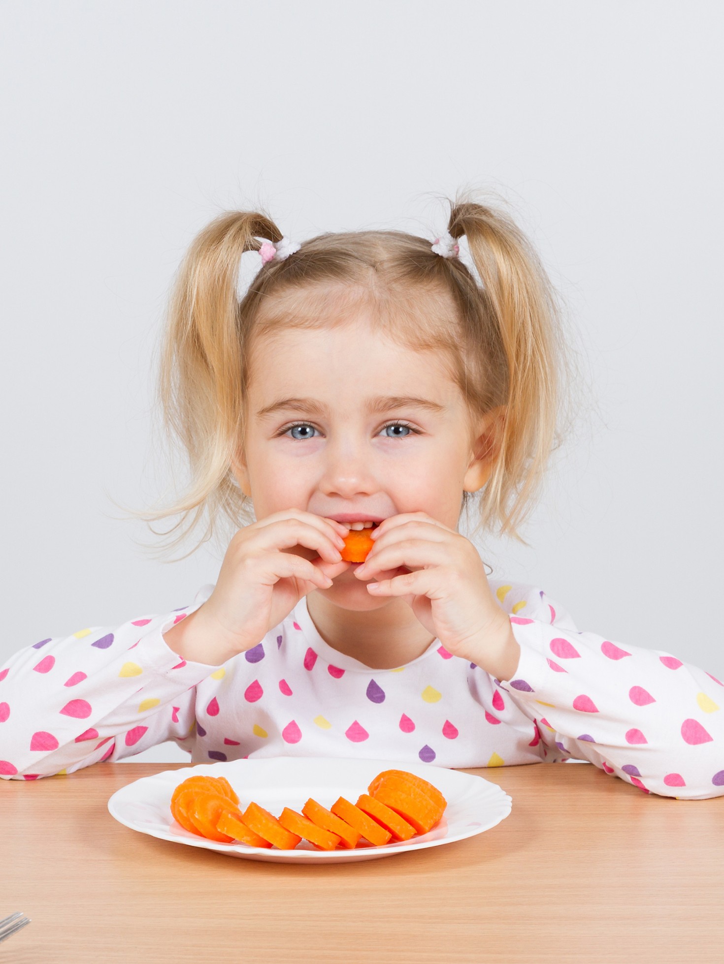 Little girl eating carrots