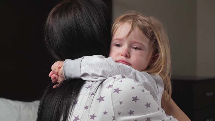 Mom soothes her daughter, child cries in room in arms of his mother. 