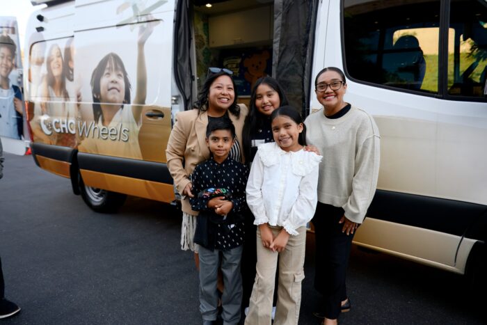 Dr. Casilang (left) with Grace and her family—mom and two siblings—standing outside the Breathmobile.