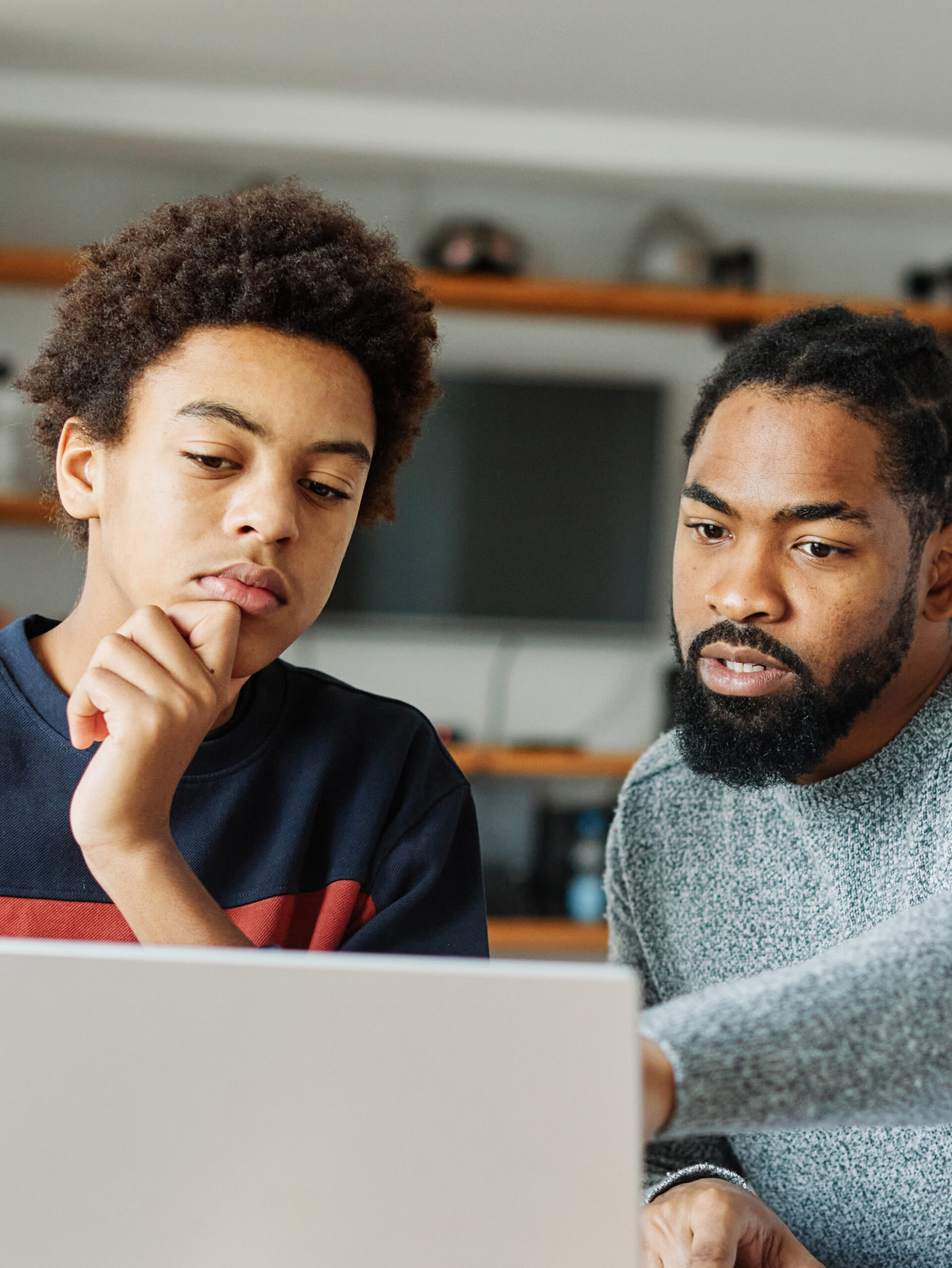 dad and son look at computer together