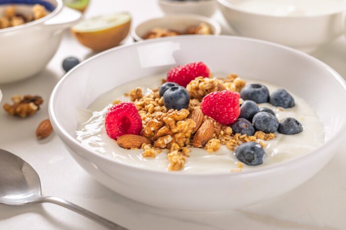 Healthy protein-rich breakfast bowl with Greek yogurt with granola, fresh blueberries, raspberries and almonds
