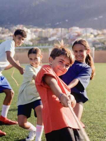 Group of children playing sport games in training field