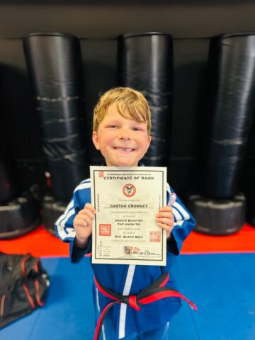 Easton holding his karate award certificate