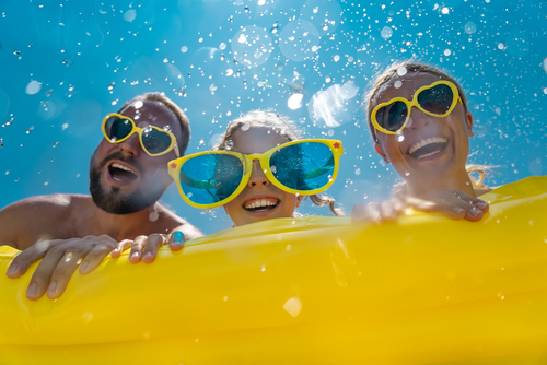 Family having fun on summer vacation. People jumping in swimming pool. Active lifestyle concept. Summer break!