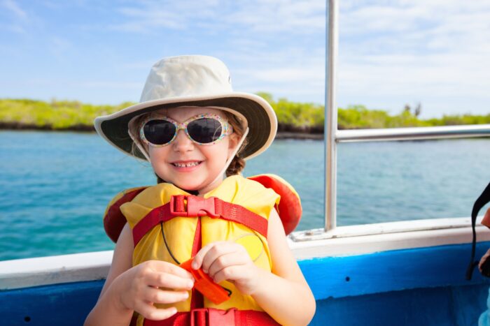 Adorable little girl in a life jacket traveling on boat