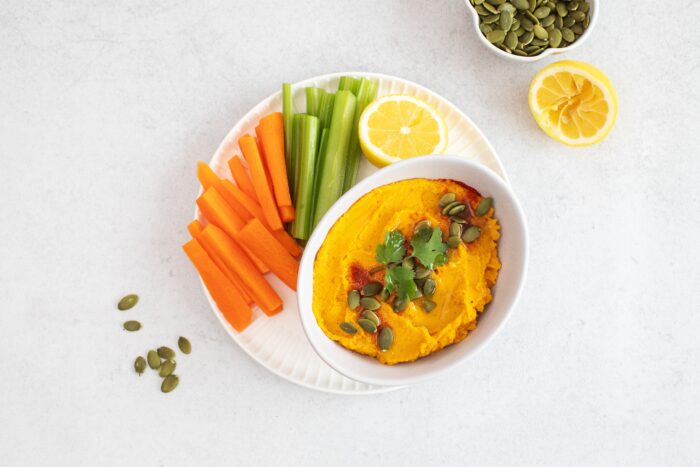 Healthy pumpkin hummus with fresh vegetables and pumpkin seeds for snack. Healthy food