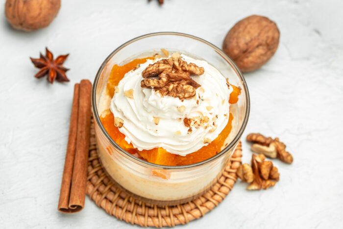 Pumpkin parfait with nuts in glass on a light background. banner, menu, recipe place for text, top view.