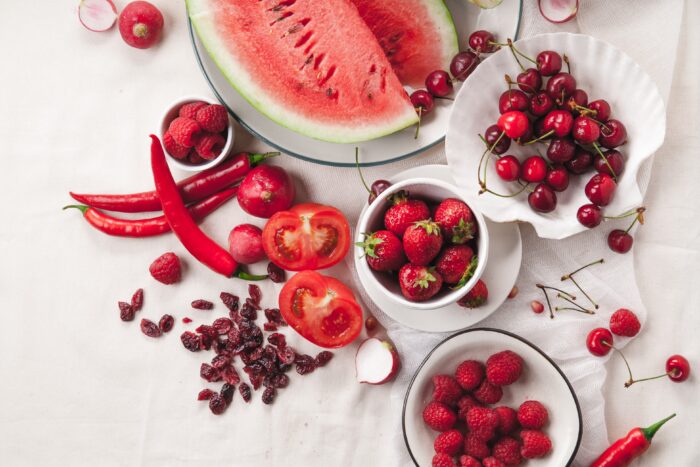 Red fruit and vegetable composition on linen fabric. Summer natural beauty concept with copy space.