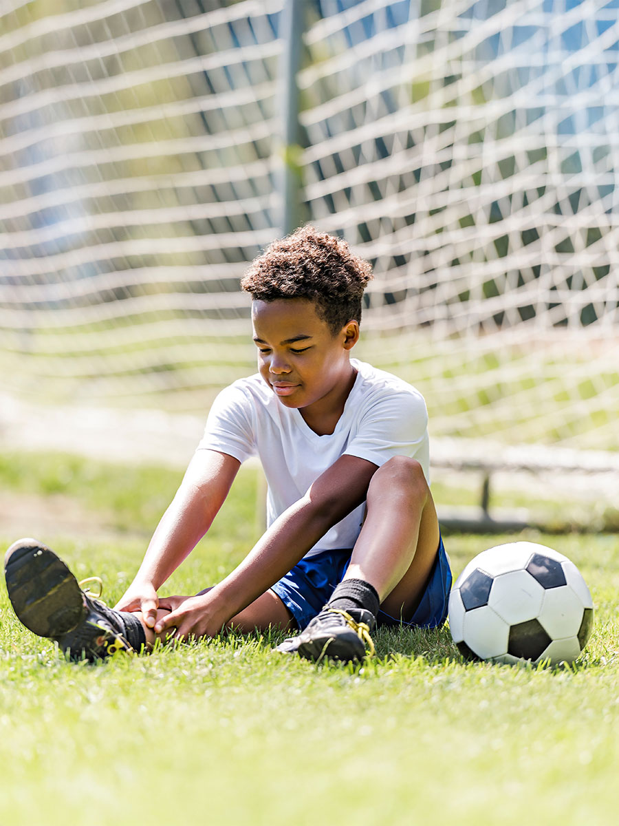 A hispanic soccer player outdoor in sunny day having ankle injury