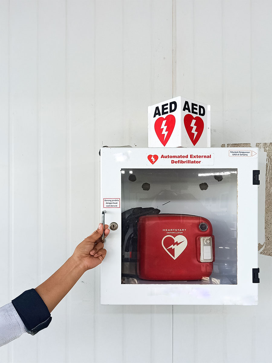 woman's hand opens AED (automatic external defibrillation) box